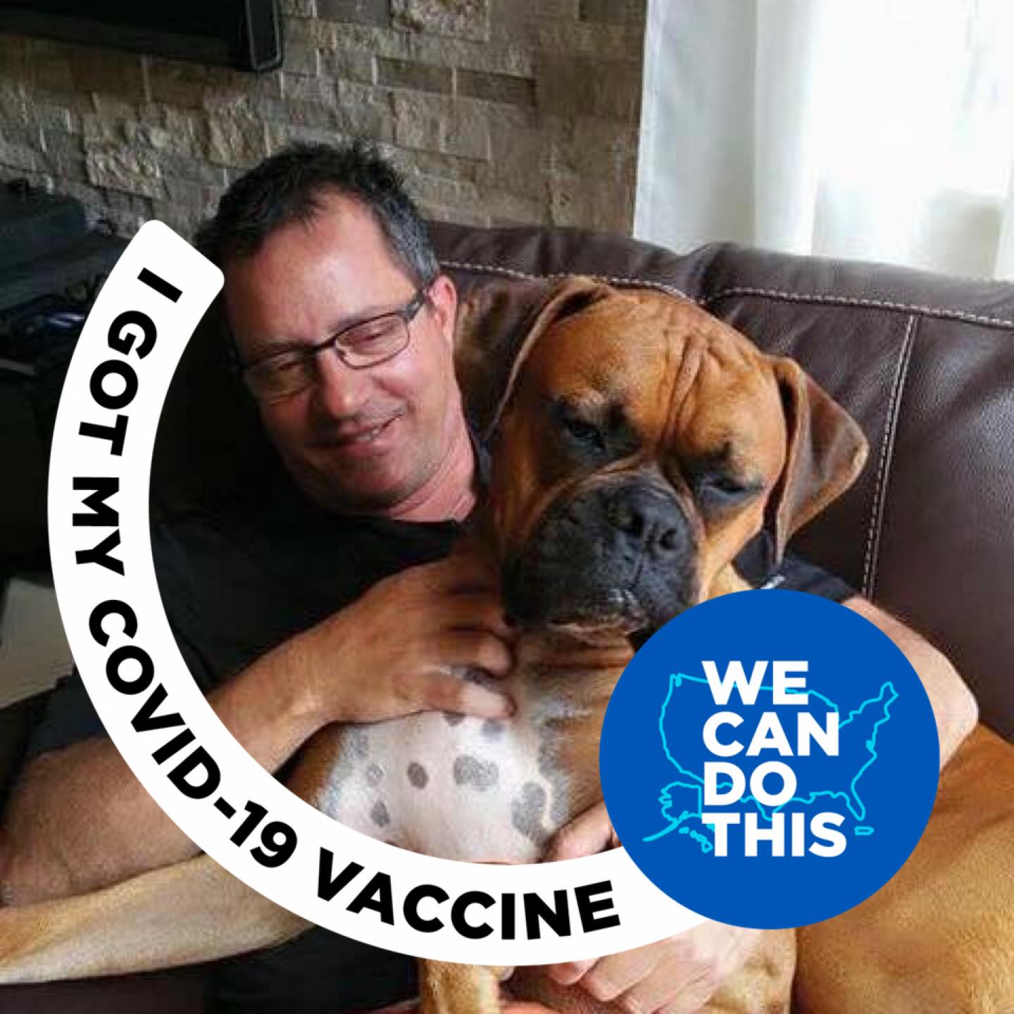 Čovjek drži boxera u naručju i sjedi u kožnoj fotelji